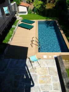 a swimming pool with chairs and a wooden deck at Il Lavatoio in Cissano