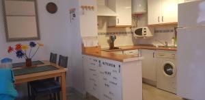 カルタヤにあるStudio loft Nuevo Portilのキッチン(白いキャビネット、テーブル、シンク付)