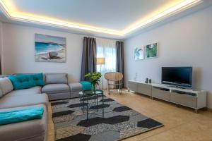 ein Wohnzimmer mit Sofa und Flachbildfernseher in der Unterkunft Villa, Private heated pool and jacuzzi . in Maspalomas