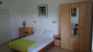 a small bedroom with a bed and a cabinet at Luce di Sole Apartment in Sveti Nikola