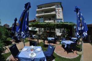 eine Gruppe von Tischen und Stühlen vor einem Gebäude in der Unterkunft Hotel Royal in Kraljevo