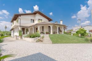 a large white house with a driveway at B&B ARMONIE DI CAMPAGNA in Galliera Veneta