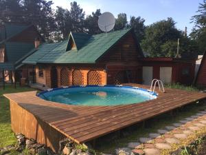 una piscina con terraza de madera junto a una casa en Holiday House Aveliya en Souzga