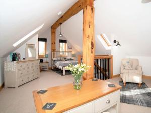 a bedroom with a bed and a vase of flowers on a table at Rowanlea Lodge Hot Tub Secure Garden Pub 5 min walk in Laurencekirk +19 photos