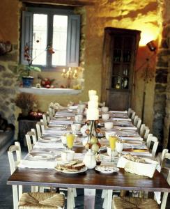 a long table in a room with white plates and candles at Casa do Castelo de Andrade in Puentedeume