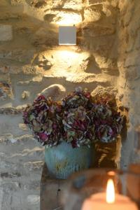 une bougie et un vase avec une plante dans un mur de pierre dans l'établissement FOUR DE CONY, à Saumane-de-Vaucluse