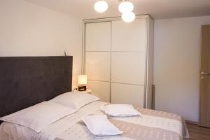 sypialnia z łóżkiem z białą pościelą i poduszkami w obiekcie Apartment Verica in Duće - 20 Meters From The Beach w mieście Dugi Rat