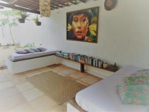 Habitación con cama y pintura en la pared en Pousada Infinito Azul, en Prea