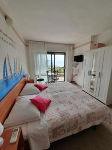 a bedroom with a large bed with red pillows at Kvarner View Rooms in Kraljevica