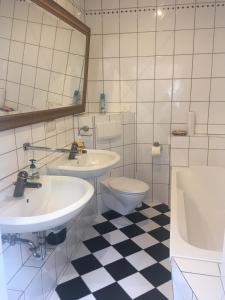 ein Badezimmer mit zwei Waschbecken, einem WC und einem Spiegel in der Unterkunft Apartment am Friedrich Ebert Park mit über 100qm Wohnfläche in Hamm