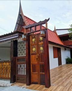 uma casa com um portão e portas de madeira em Chanida home em Phra Nakhon Si Ayutthaya