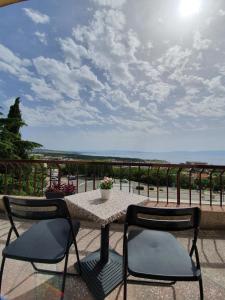 a table and chairs on a patio with a view of the ocean at Kvarner View Rooms in Kraljevica