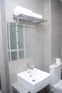 a bathroom with a sink and a mirror and a toilet at Rest And Comfort Boutique Hotel in Kuala Terengganu