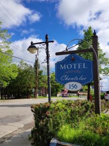 a sign for a motel with a street light at Motel Chantolac in Sainte-Adèle