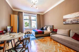 uma sala de estar com um sofá e uma mesa em Garden Apartments em Praga