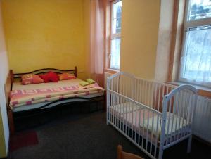 ein Schlafzimmer mit einem Bett und zwei Babys darin in der Unterkunft Penzion Volyňka in Vimperk