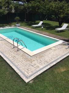 een zwembad in het gras met twee stoelen eromheen bij camera con giardino e piscina in Scafati