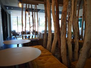 un restaurant avec des tables, des chaises et des arbres dans l'établissement ibis Styles Arcachon Gujan Mestras, à Gujan-Mestras