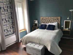 a bedroom with a large bed with blue walls at LE JABLOIRE in Florent-en-Argonne +41 photos