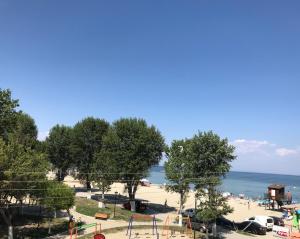 un parco con parco giochi e la spiaggia di Aqua Beachfront Elegant Hotel a Olympiakí Aktí