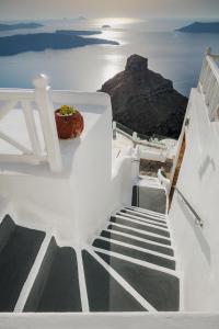 a staircase leading down to the ocean with a rock at Thea Apartments in Imerovigli