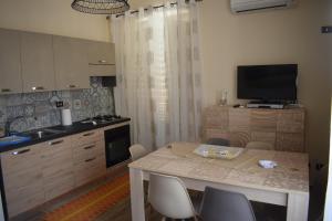 eine Küche mit einem Tisch mit Stühlen und einem TV in der Unterkunft Affitto breve Casa Taormina in Palermo