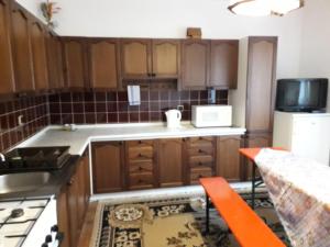 a kitchen with wooden cabinets and a white refrigerator at Ladislav in Spišské Vlachy