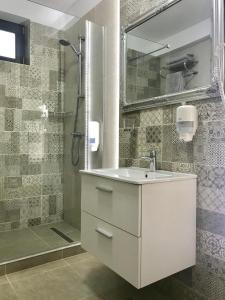 ein Badezimmer mit einem weißen Waschbecken und einer Dusche in der Unterkunft DarNiDa Luxury Apartment in Mamaia Nord – Năvodari
