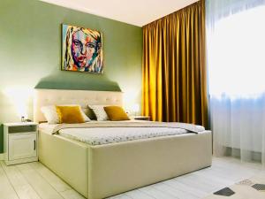 Schlafzimmer mit einem Bett mit Wandgemälde in der Unterkunft DarNiDa Luxury Apartment in Mamaia Nord – Năvodari