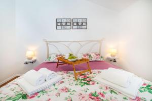 a bedroom with a bed with a table on it at Apartman ZOZZY in Posedarje
