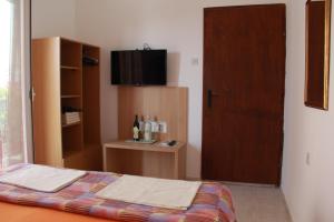 a bedroom with a bed and a tv on a door at Mitko Apartments in Budva