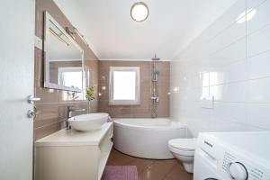 a bathroom with a tub and a sink and a toilet at Apartman ZOZZY in Posedarje +37 photos