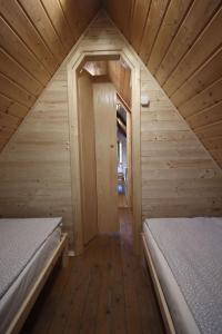 a small room with two beds in a wooden cabin at Erdő Kapitánya Vendégház in Tata