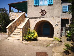 ein Gebäude mit einer blauen Tür, einer Treppe und Blumen in der Unterkunft Oaza in Krk