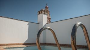 a pool with two metal rails in front of a building at Apartamento El Teatro in Écija