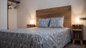 a bedroom with a bed with a wooden headboard and pillows at Apartamento El Teatro in Écija +17 photos