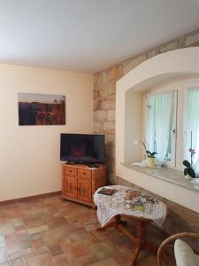 a living room with a television and a table at Ferienwohnung "WILLI" in Hohnstein