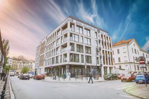 duży biały budynek przy ulicy miejskiej z samochodami w obiekcie RAJSKA 3 by PI Apartments w Krakowie