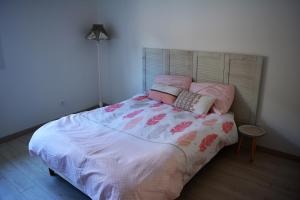 a bedroom with a bed with pink and white sheets at Villa Fleur des Pins 2 personnes Dune du Pyla in Gujan-Mestras