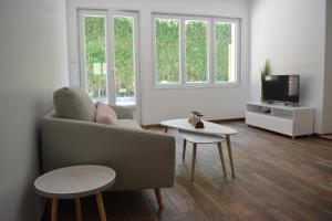 a living room with a couch and a tv at Villa Fleur des Pins 2 personnes Dune du Pyla in Gujan-Mestras