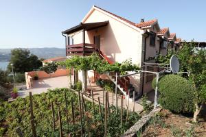 a house with a bunch of grapes in a garden at Bridgeview apartment in Trogir
