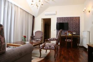 a living room with a table and a desk with chairs at Hotel Villa Viktorija in Banja Luka