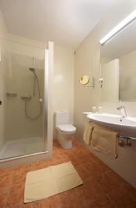 a bathroom with a shower and a sink and a toilet at Seehotel Garni Pöllmann in Mondsee