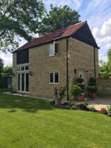 a large brick house with a grass yard at The Old Barn 26 Church Street in Market Deeping