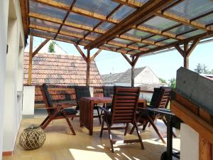 un patio con sillas y una pérgola de madera en Apartmán s vinným sklepem Four Grapes, en Jevišovka