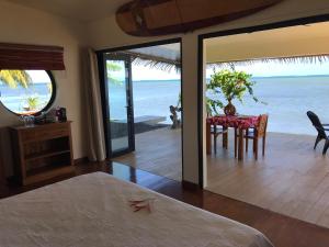 a bedroom with a table and a view of the ocean at Ocean Breeze Bungalow in Tevaitoa