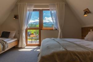 a bedroom with a bed and a large window at Willa Rychlina in Zakopane