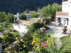 eine Gruppe von Menschen, die in einem Garten mit Blumen sitzen in der Unterkunft Sierra y Mar in Ferreirola