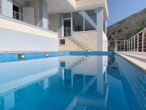 a house with a swimming pool in front of it at Vitamin Sea in Sarandë