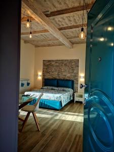 a bedroom with a bed and a table and a chair at RESIDENZA MARIA ANTONIETTA - 50 METRI DAL MARE in Pizzo